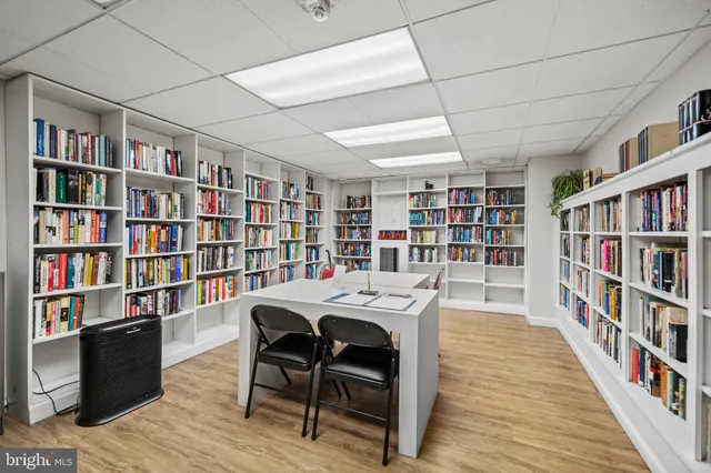 a view of a workspace with furniture lots of books