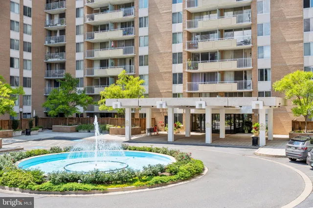 a front view of a building with a garden and plants