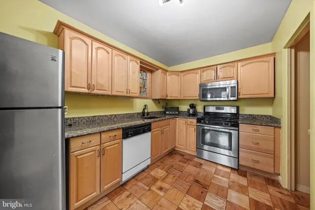 a kitchen with stainless steel appliances granite countertop a refrigerator sink and stove