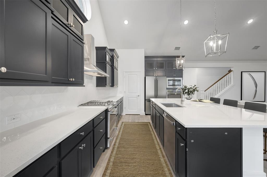 1004 Ashcroft Lane Justin, TX 76247 - Photo 7 of 39 a kitchen with a sink counter top space cabinets and stainless steel appliances