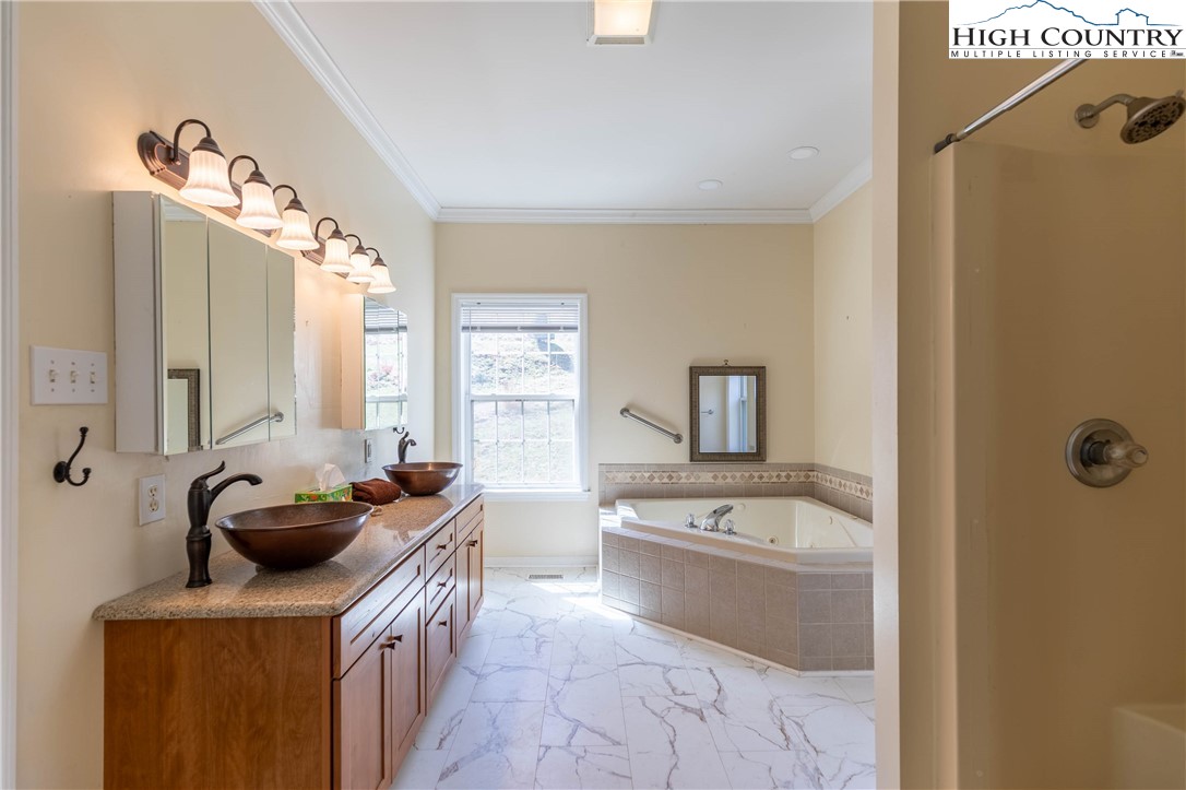 449 Meadow Ridge Drive Jefferson, NC 28640 - Photo 14 of 37 a bathroom with a tub sink and mirror