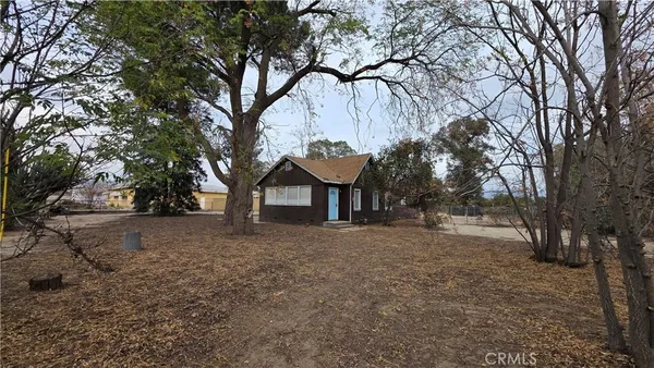 a view of a house with a tree and wooden fence