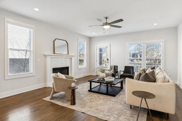 a living room with furniture kitchen view and a chandelier