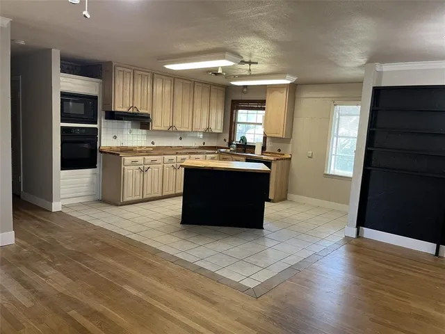 a large kitchen with stainless steel appliances granite countertop a stove and a refrigerator
