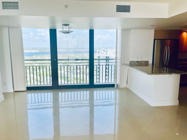 a view of a kitchen with stainless steel appliances wooden floor and a large window