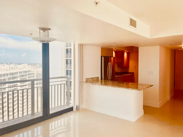 a view of a hallway with wooden floor and cabinet