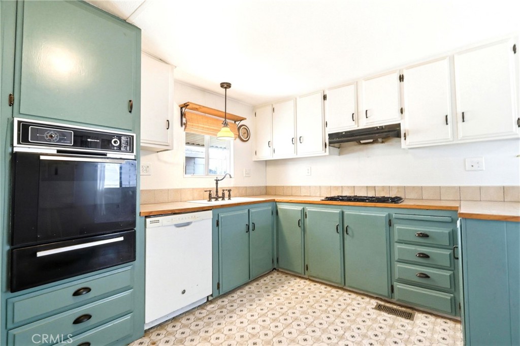 9391 California Avenue, Unit 35 Riverside, CA 92503 - Photo 12 of 32 a kitchen with stainless steel appliances a stove a sink and white cabinets