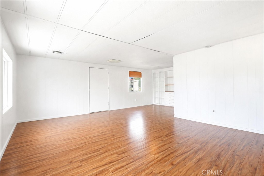 9391 California Avenue, Unit 35 Riverside, CA 92503 - Photo 6 of 32 a view of an empty room with wooden floor and a window