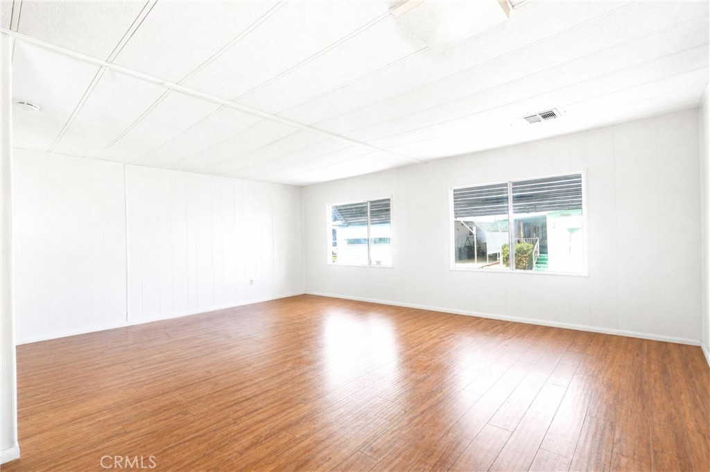 9391 California Avenue, Unit 35 Riverside, CA 92503 - Photo 9 of 32 an empty room with wooden floor and windows