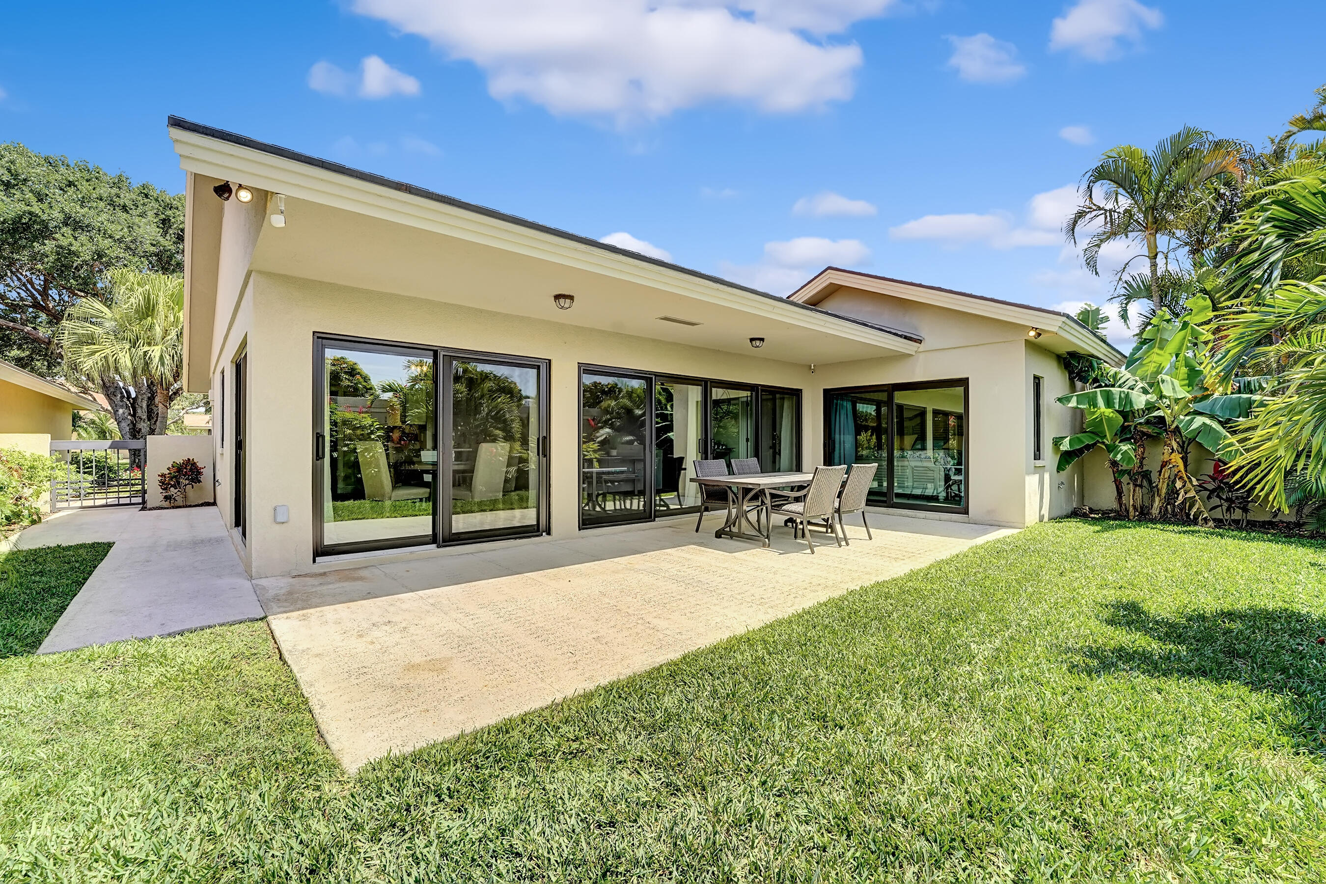 118 Ridge Road Jupiter, FL 33477 - Photo 26 of 27 a view of a patio with couches and table and chairs next to yard