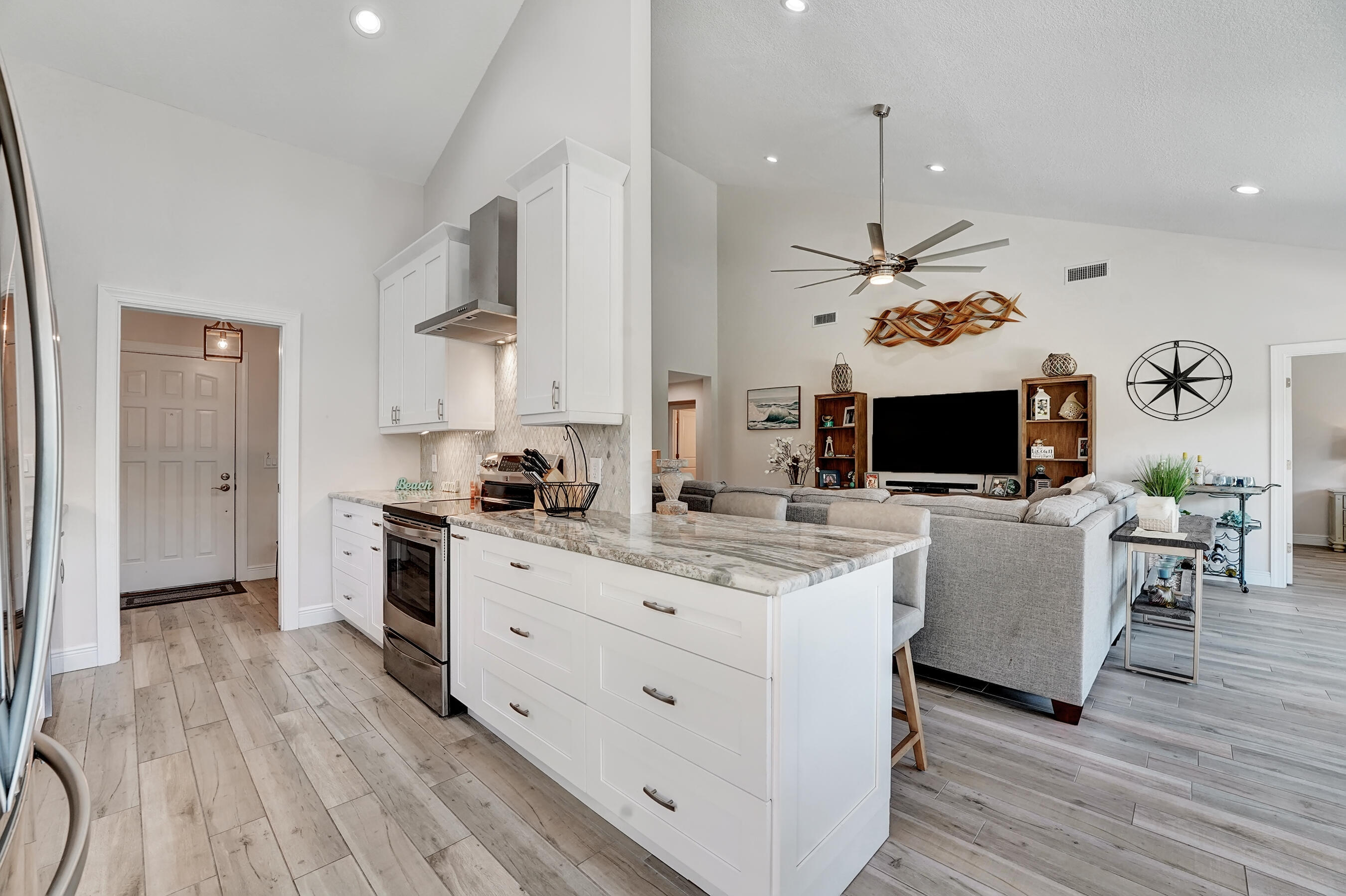 118 Ridge Road Jupiter, FL 33477 - Photo 6 of 27 a large white kitchen with a large island in the center and stainless steel appliances