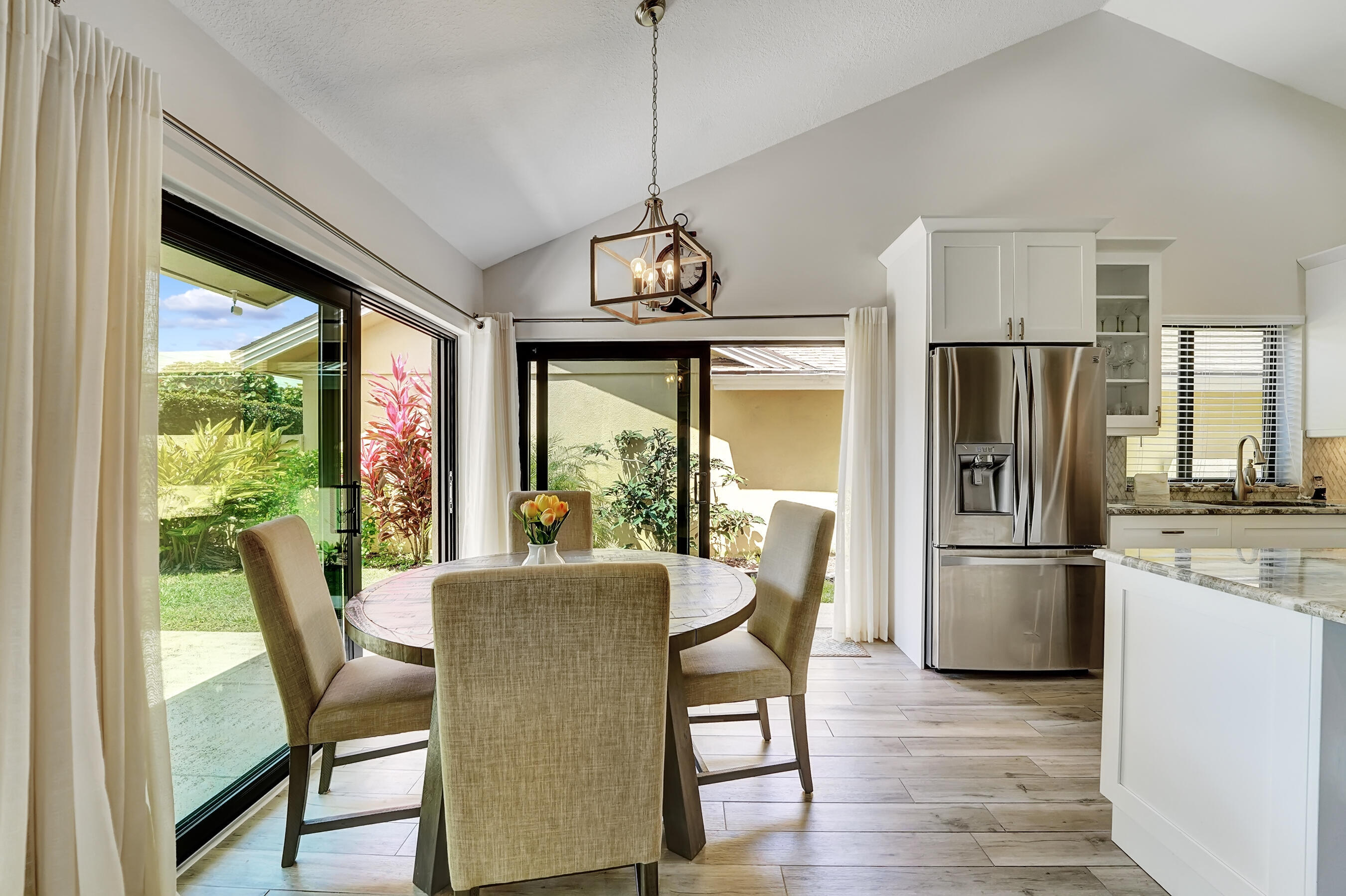 118 Ridge Road Jupiter, FL 33477 - Photo 8 of 27 a dining room with furniture a chandelier and wooden floor