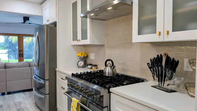 a kitchen with stainless steel appliances granite countertop a stove a sink and a refrigerator