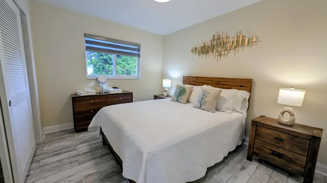 a bedroom with a bed and a lamp on dresser