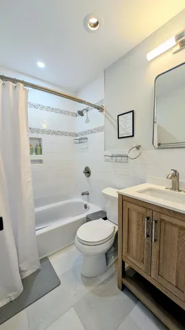 a bathroom with a double vanity sink toilet mirror and bathtub