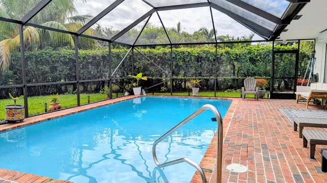 a view of a swimming pool with a porch and furniture