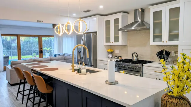 a kitchen with stainless steel appliances kitchen island granite countertop a table chairs in it and wooden floors