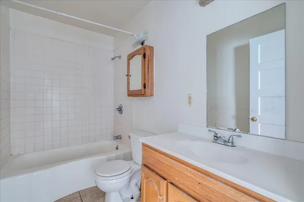 a bathroom with a granite countertop sink a toilet and a bathtub