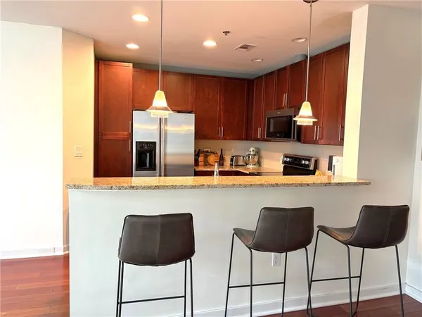 a kitchen with stainless steel appliances granite countertop a stove a sink and a refrigerator