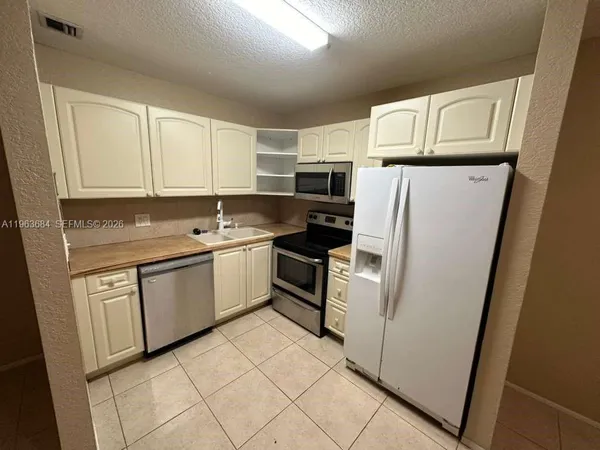 a kitchen with white cabinets and white appliances