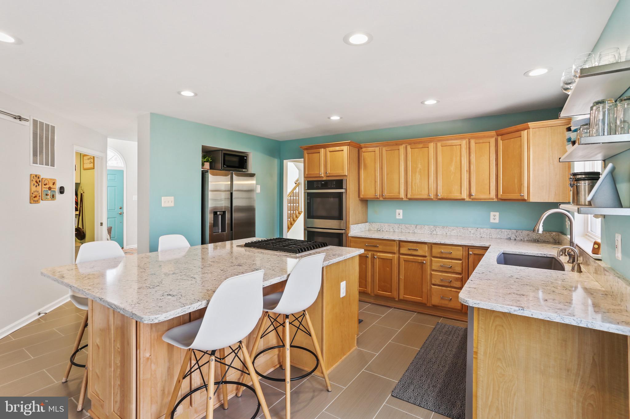 5810 Artisan Drive Eldersburg, MD 21784 - Photo 5 of 39 a kitchen with granite countertop sink cabinets dining table and chairs