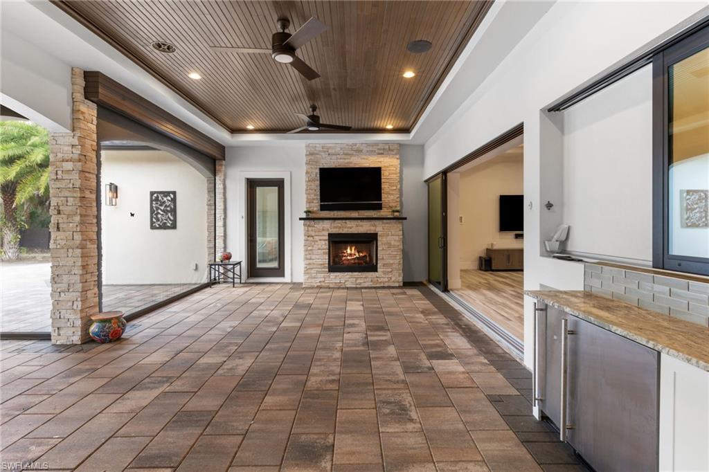 4501 3rd Avenue Southwest Naples, FL 34119 - Photo 38 of 50 Screened patio with summer kitchen, ice maker, fridge, and gas fireplace