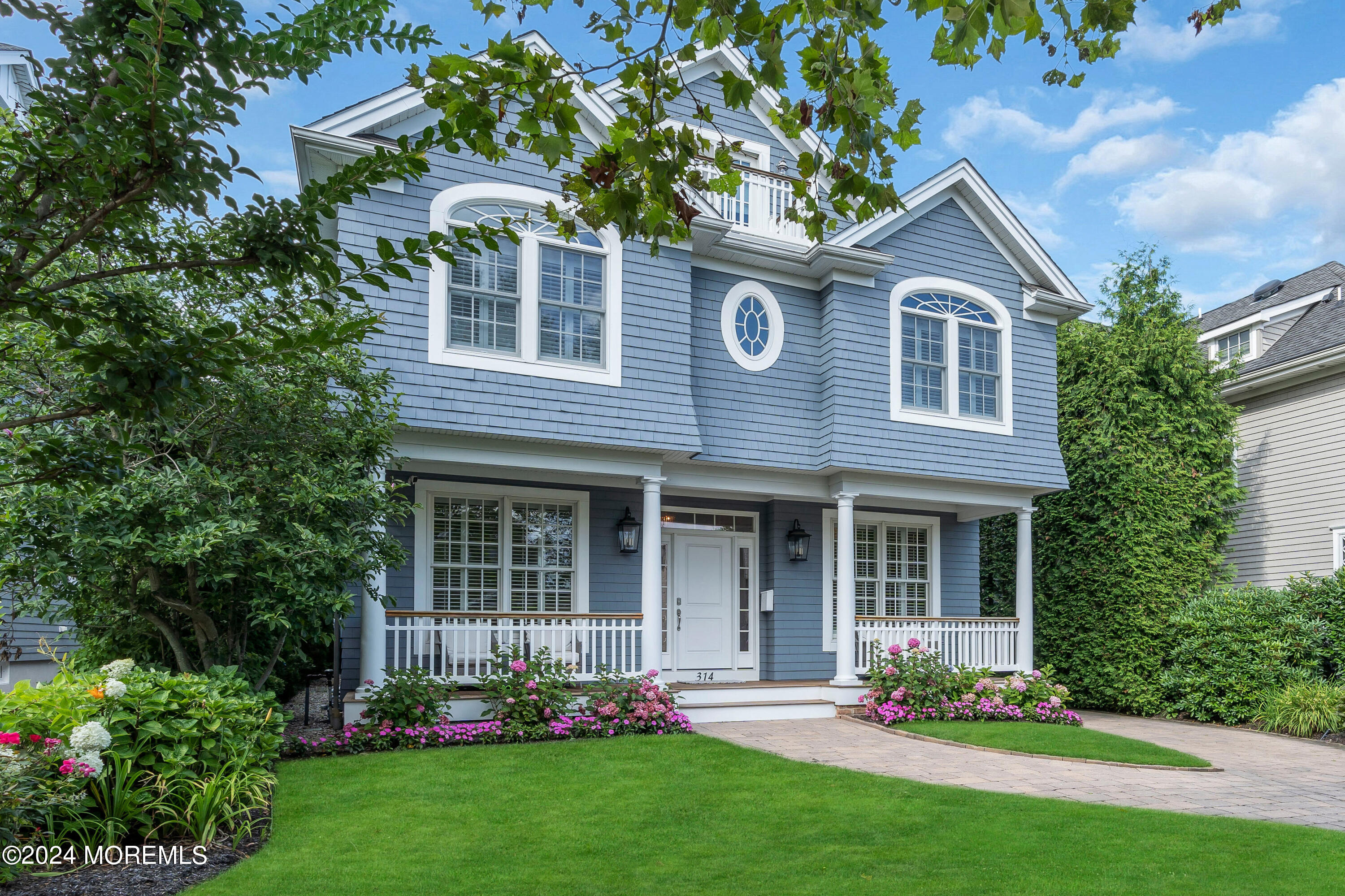 a front view of a house with a yard and potted plants