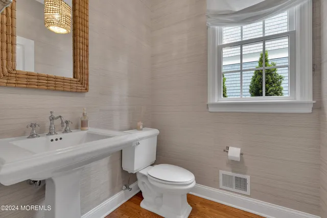 a bathroom with a sink a toilet and a mirror