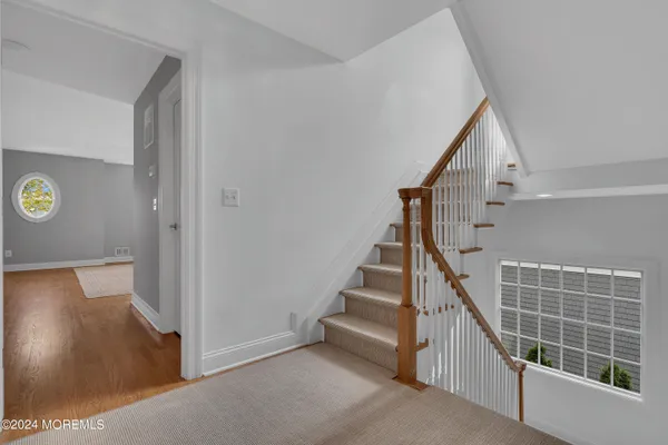 a view of staircase with railing and white walls