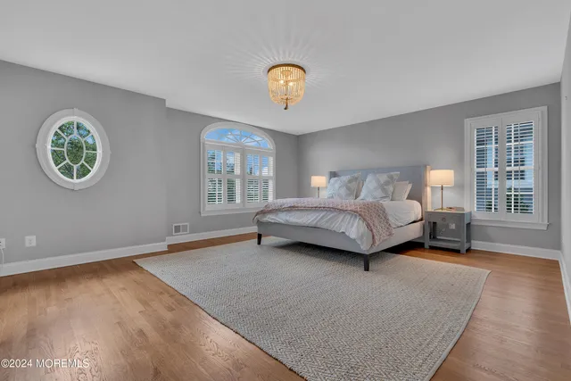 a spacious bedroom with a bed a table and a window