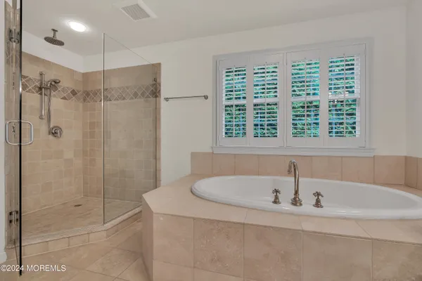 a white bath tub sitting next to a shower
