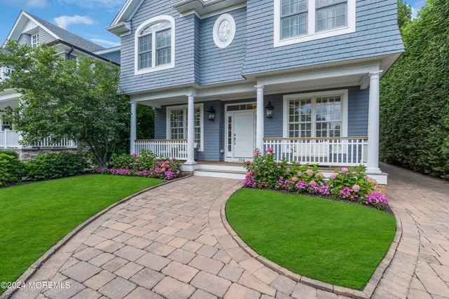 a front view of a house with a garden and plants