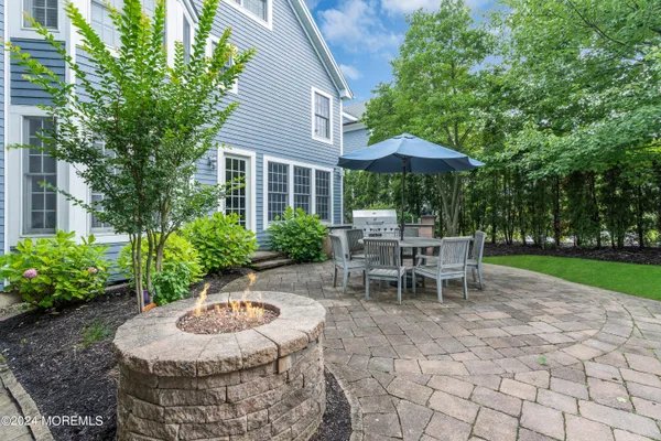 a view of a patio with a table and chairs under an umbrella