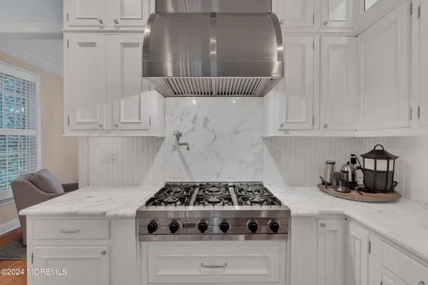 a kitchen with a stove and white cabinets