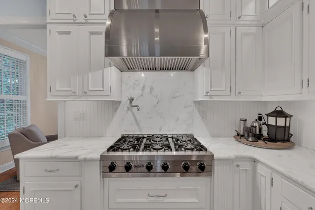 a kitchen with a stove and white cabinets