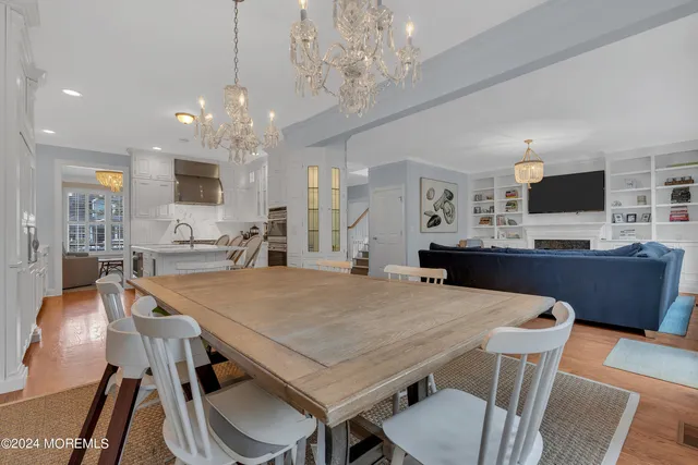 a view of a dining room with furniture a chandelier and wooden floor