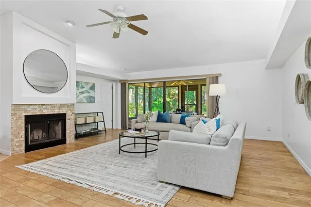a living room with couches a large window with wooden floor