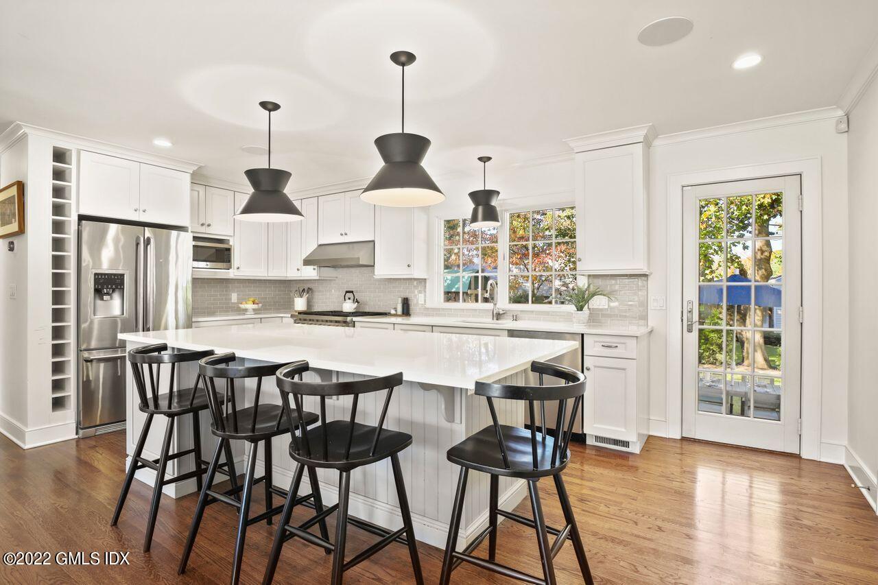 6 Ernel Drive Riverside, CT 06878 - Photo 5 of 26 a kitchen with stainless steel appliances a table chairs sink and wooden cabinets