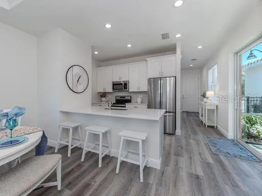 a kitchen with stainless steel appliances a refrigerator and a table