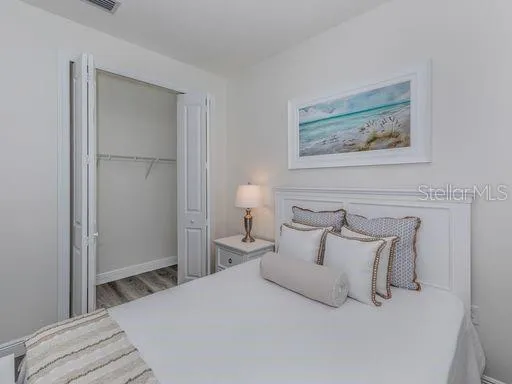 a bedroom with a bed and a painting on the wall