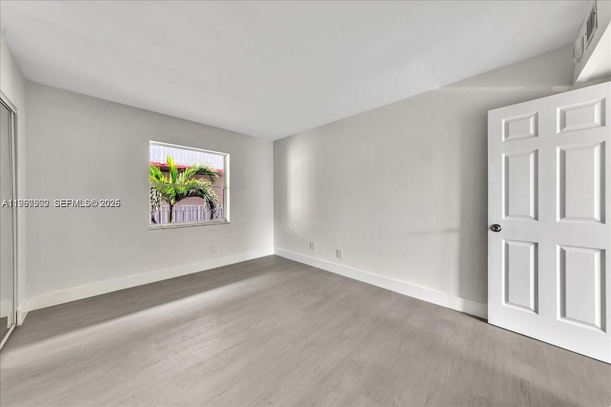 1750 West 46th Street, Unit 433 Hialeah, FL 33012 - Photo 12 of 27 an empty room with windows and ceiling fan