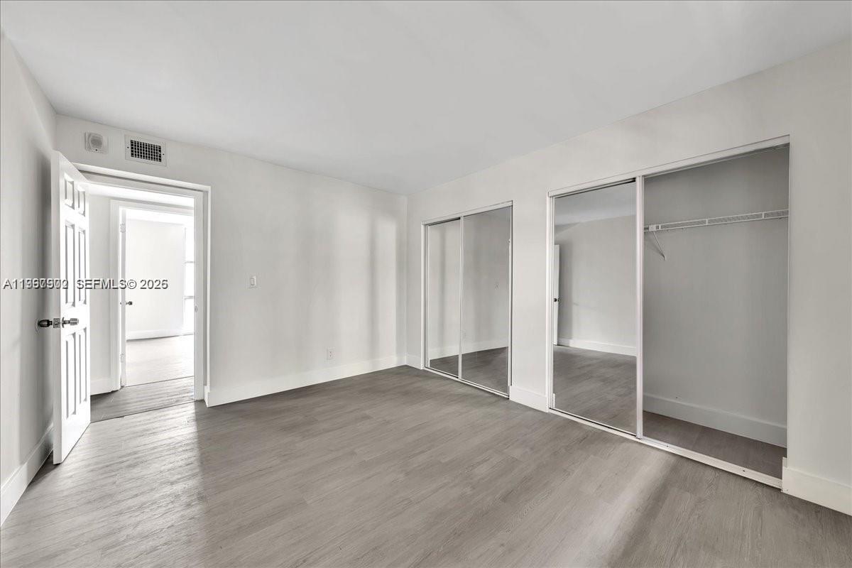 1750 West 46th Street, Unit 433 Hialeah, FL 33012 - Photo 13 of 27 a view of an empty room with wooden floor