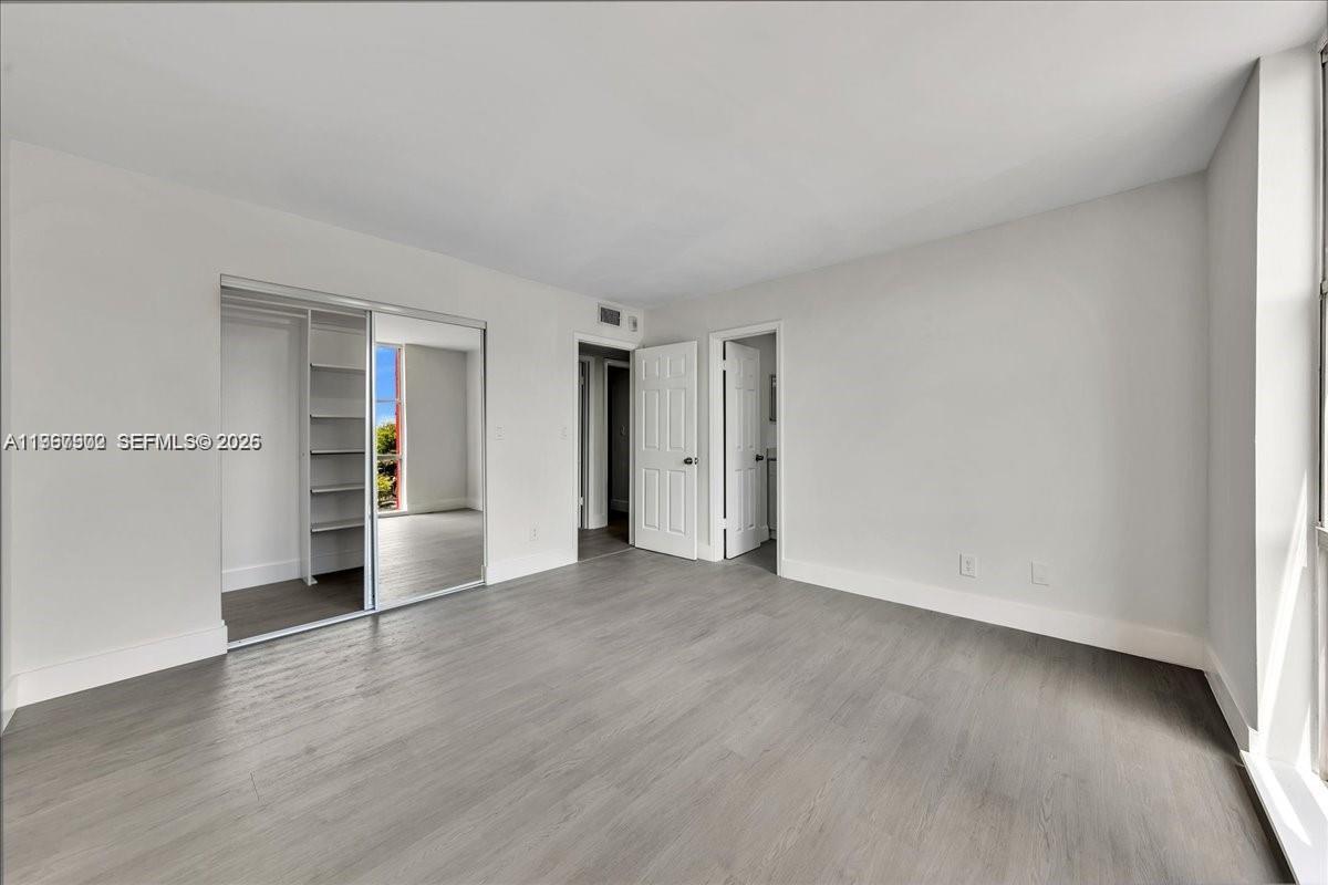 1750 West 46th Street, Unit 433 Hialeah, FL 33012 - Photo 16 of 27 a view of an empty room with wooden floor and a window