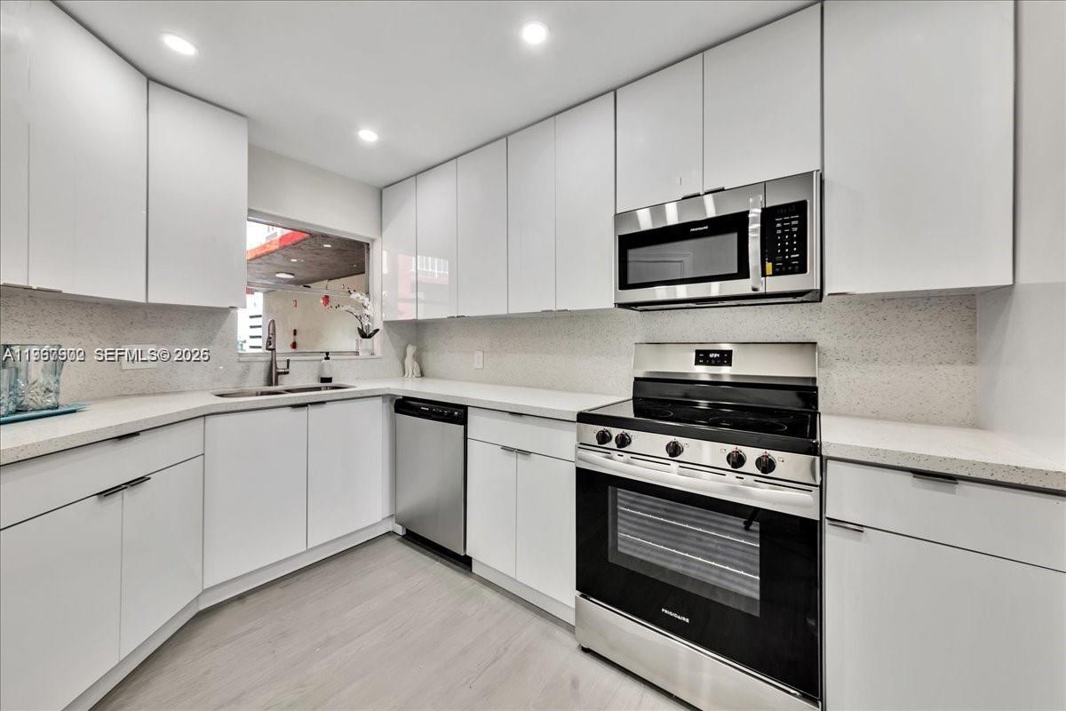 1750 West 46th Street, Unit 433 Hialeah, FL 33012 - Photo 2 of 27 a kitchen with stainless steel appliances white cabinets and a stove a oven with white countertops
