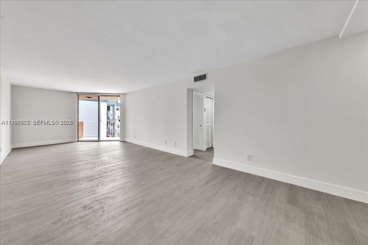 1750 West 46th Street, Unit 433 Hialeah, FL 33012 - Photo 5 of 27 a view of an empty room with wooden floor
