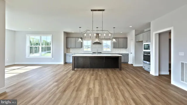a view of a kitchen with wooden floor and a window