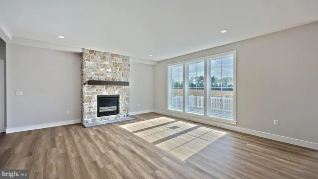 a view of an empty room with a fireplace and a window