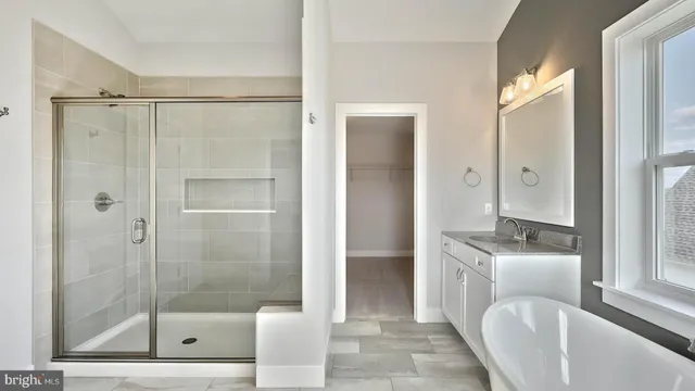 a bathroom with a bathtub shower sink and mirror