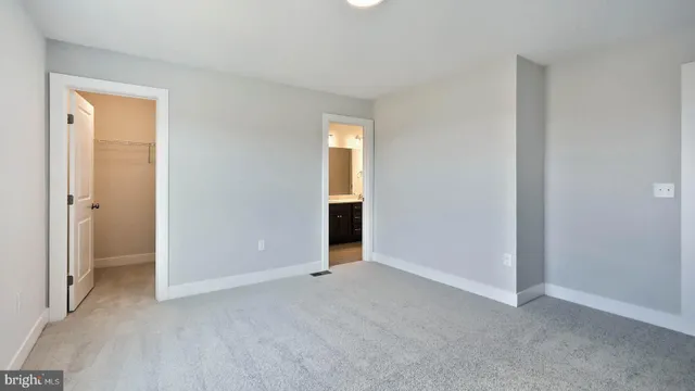 an empty room with closet and a bathroom