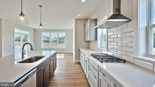 a kitchen with sink a stove and chairs